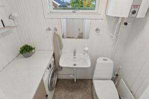 a small bathroom with a sink and a washing machine at Quiet Holiday Home With Annex And Great Outdoor in Bogø By +23 photos
