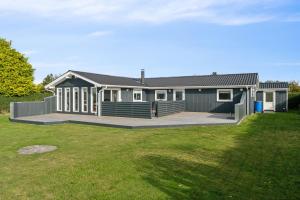 a large house with a large deck in a yard at Quiet Holiday Home With Annex And Great Outdoor in Bogø By