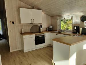 a kitchen with white cabinets and a stove top oven at Fantastic Spa Holiday Home in Hemmet