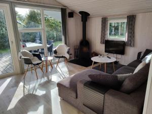 a living room with a couch and chairs and a tv at Fantastic Spa Holiday Home in Hemmet
