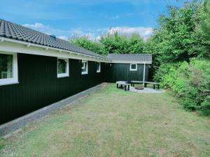 a yard next to a building with a picnic table at Fantastic Spa Holiday Home in Hemmet