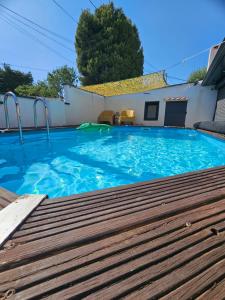 a large blue swimming pool with a wooden deck at Bella Villa Piscine & jacuzzi in Marseille