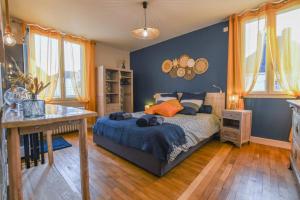 a bedroom with a bed and a table and windows at Les halles du temps in Bar-sur-Seine