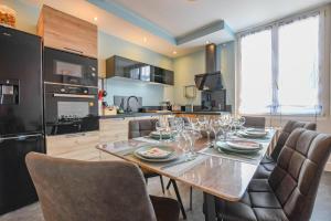 a kitchen with a dining table and chairs and a kitchen with at Les halles du temps in Bar-sur-Seine