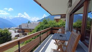a balcony with a table and chairs and mountains at Panorama 14 in Bagnes