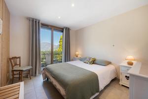 a bedroom with a bed and a large window at Maison "Casabert" in Saint-Martin-de-la-Porte