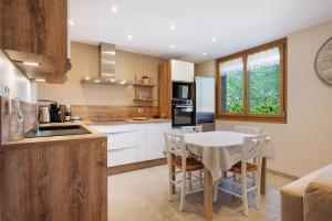 a kitchen with a table and chairs in a kitchen at Maison "Casabert" in Saint-Martin-de-la-Porte