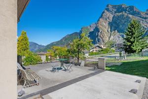 a patio with a table and chairs and a mountain at Maison "Casabert" in Saint-Martin-de-la-Porte