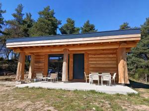 a cabin with tables and chairs in front of it at L'ecorce sauvage 4/6 pers in Rocles