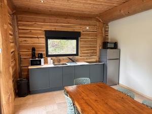 a kitchen with a table and a refrigerator at L'ecorce sauvage 4/6 pers in Rocles