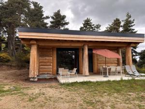 a cabin with a table and chairs and a roof at L'ecorce sauvage 4/6 pers in Rocles +9 photos