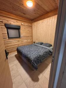 a bedroom with a bed in a wooden room at L'ecorce sauvage 4/6 pers in Rocles