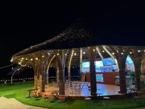 a gazebo with tables and chairs and lights at Cát Lý Camping in Ha Giang