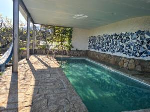 a swimming pool in a house with a rock wall at El Valle in Piedralaves