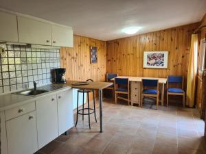 a kitchen with a sink and a table with chairs at El Valle in Piedralaves
