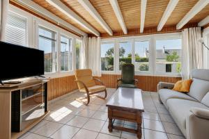 a living room with a couch and a tv at Vacances chez Lulu in Batz-sur-Mer
