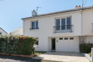 a white house with a garage at Vacances chez Lulu in Batz-sur-Mer