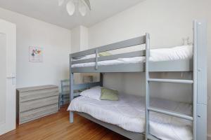 a bedroom with two bunk beds and a night stand at Vacances chez Lulu in Batz-sur-Mer