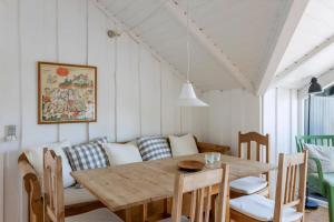 a dining room with a table and a couch at Idyllic Summer House Close To Beach And Forest in Tisvildeleje