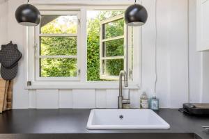 a kitchen with a sink and two windows at Idyllic Summer House Close To Beach And Forest in Tisvildeleje +31 photos