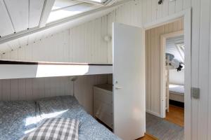 a small bedroom with a bed and a skylight at Idyllic Summer House Close To Beach And Forest in Tisvildeleje