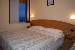 a bedroom with a large bed with a large window at Villaggio Club Tortorella in Marina di Casalvelino +16 photos