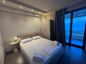 a bedroom with a bed and a large window at nafsea in Afitos