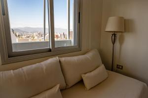 a couch in a room with a large window at Delta Boutique Loft, en el centro de Salta, para 3 by BEDBOOK in Salta