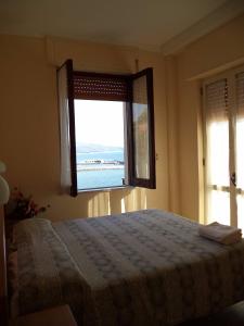 a bedroom with a bed and a large window at Villaggio Club Tortorella in Marina di Casalvelino