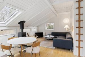 a living room with a couch and a table at Charming Cottage Near The Water in Holbæk