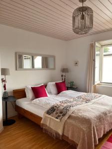 a bedroom with a large bed with red pillows at B&B Alpenblick in Erlinsbach