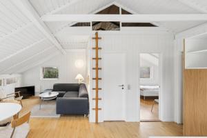a living room with a couch and a bed at Charming Cottage Near The Water in Holbæk