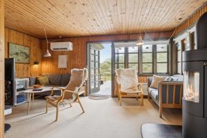 a living room with a couch and a table and chairs at Summerhouse In Peaceful Surroundings in Pandrup