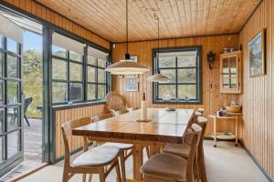 a dining room with a large wooden table and chairs at Summerhouse In Peaceful Surroundings in Pandrup