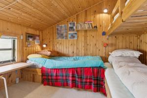 a bedroom with two beds in a wooden cabin at Summerhouse In Peaceful Surroundings in Pandrup