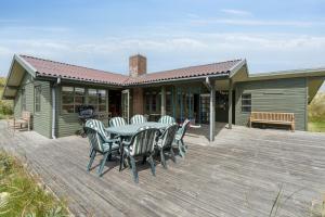 a deck with a table and chairs on a house at Summerhouse In Peaceful Surroundings in Pandrup