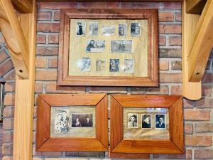 two pictures on a brick wall with a picture frame at Agroturystyka Na Górze - Obrocz 116A in Obrocz