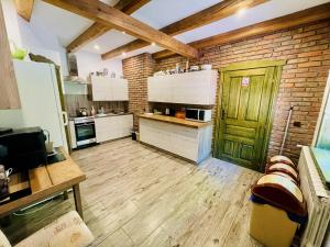 a kitchen with a wooden floor and a green door at Agroturystyka Na Górze - Obrocz 116A in Obrocz