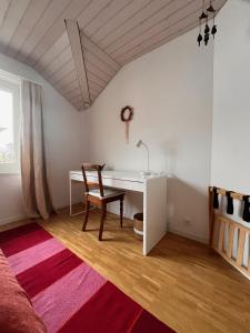 a bedroom with a desk and a chair and a bed at B&B Alpenblick in Erlinsbach