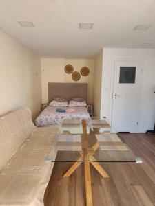 a room with a bed and a glass table at Mały Domek in Szczecinek