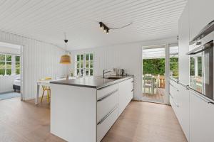 a kitchen with white cabinets and a white ceiling at Renovated Classic Cottage Close To Beach in Roslev