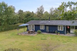 a blue house with a picnic table in a yard at Renovated Classic Cottage Close To Beach in Roslev +17 photos