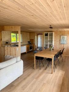 a dining room and kitchen with a table and chairs at 2-Family Activity Cottage in Rønde +13 photos