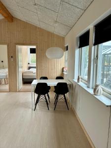 a dining room with a white table and chairs at 2-Family Activity Cottage in Rønde