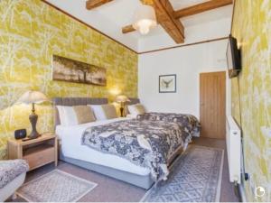 a bedroom with two beds and a yellow wall at Blenkinsopp Castle Inn in Greenhead