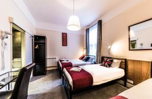 Habitación de hotel con 2 camas y espejo en Melandre Hotel By Saba en Londres
