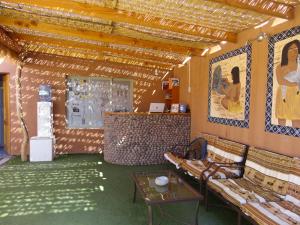 a room with couches and a table and paintings on the wall at Hostal Pablito in San Pedro de Atacama