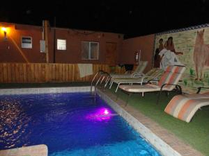 a man and a woman sitting on a bench in front of a pool at Hostal Pablito in San Pedro de Atacama
