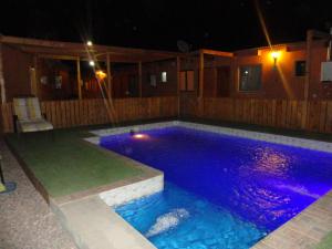 a swimming pool at night with purple lights at Hostal Pablito in San Pedro de Atacama