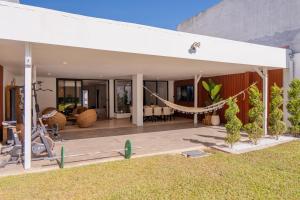 a house with a hammock in the yard at Refugio urbano in Nuevo Cuscatlán